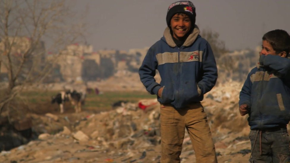 Boys stand on the edge of the Jaramana district of Damascus