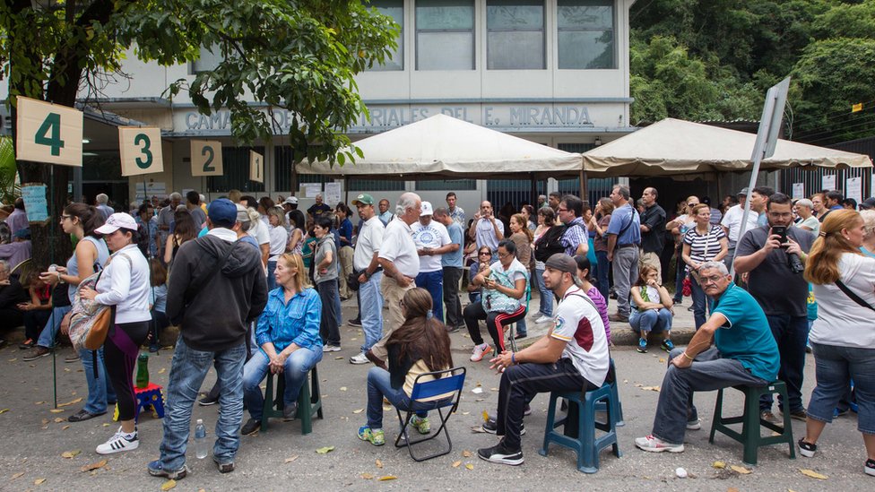 Filas de votantes ante un centro de votación.