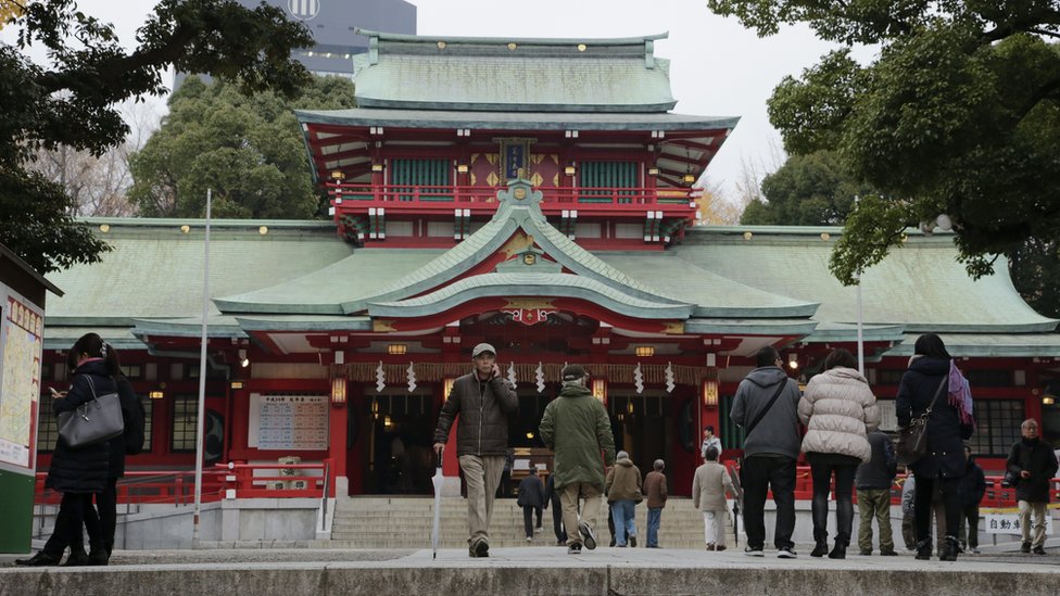 Personas caminan por el templo Tomioka Hachimangu