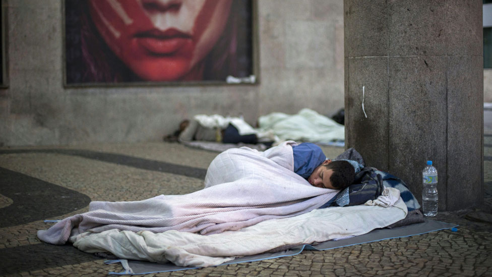 Hombre duerme en la calle en Brasil.
