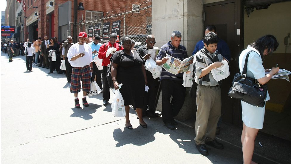 Personas en busca de empleo hacen cola en Nueva York.