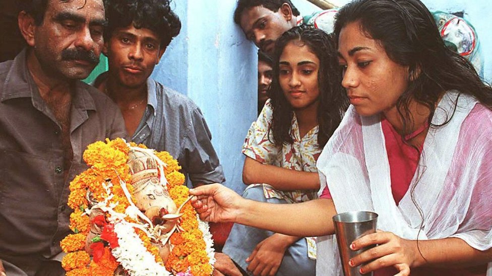 Pemeluk agama Hindu menawarkan susu ke dewa Ganesha