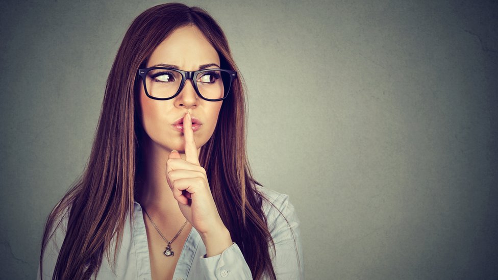 Mujer haciendo una señal de silencio