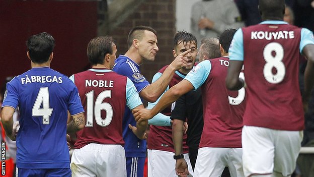 West Ham and Chelsea players surround referee Jon Moss during a game between their sides in October