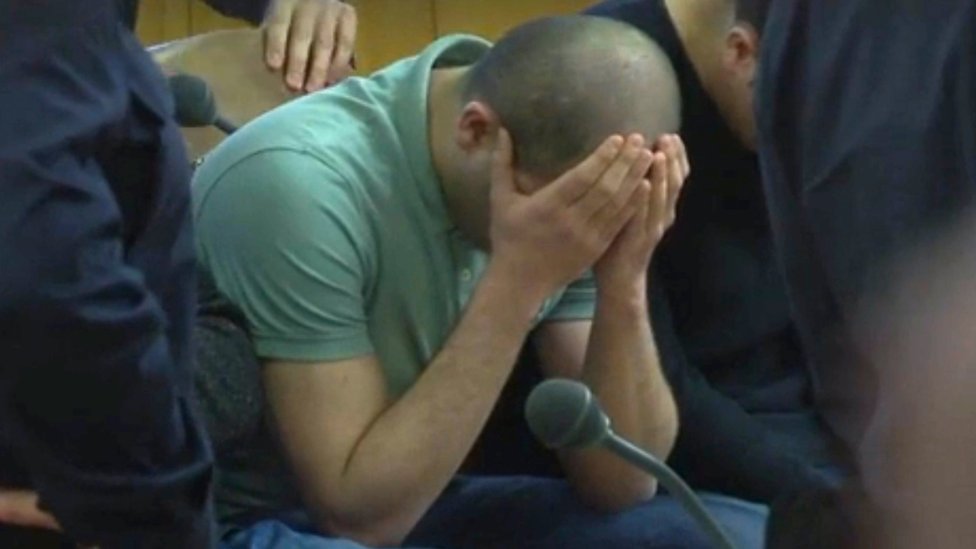 أحد المتهمين يغطي وجهه أثناء المحاكمة في فيينا