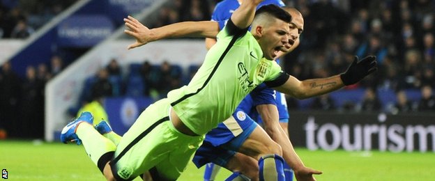 Sergio Aguero is challenged by Gokhan Inler