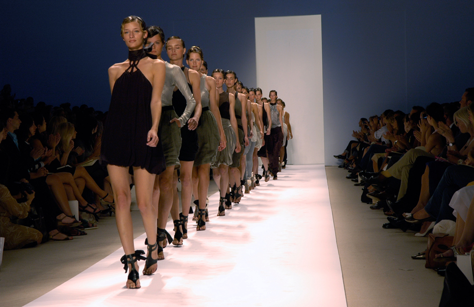 Models on a catwalk in a line