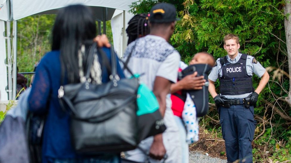 Un grupo de haitianos cruzan la frontera desde Estados Unidos hacia Canadá.