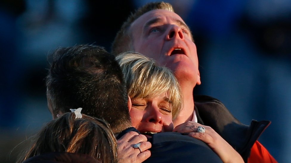 Familiares de las víctimas en la escuela de Sandy Hook se consuelan mutuamente.