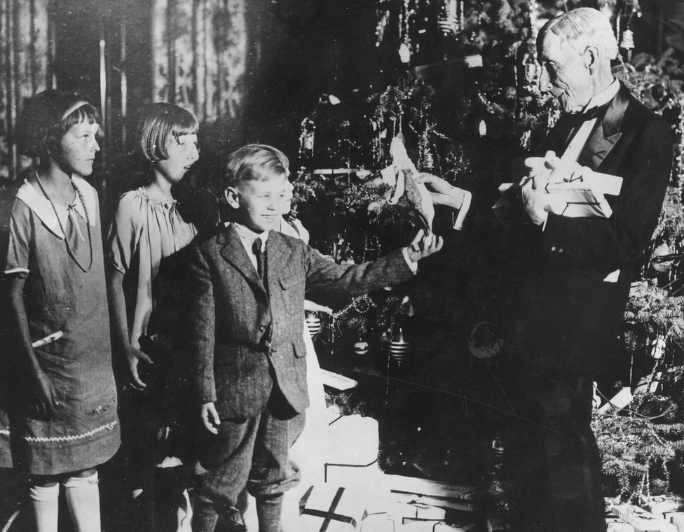 John D. Rockefeller dando regalos de Navidad a varios niños en 1930.