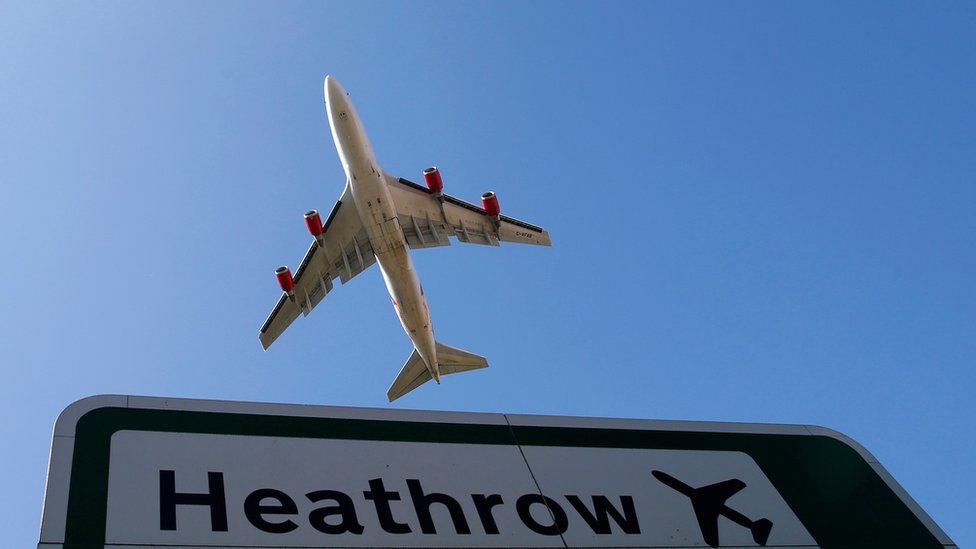 طائرة تحلق فوق لافتة تحمل اسم مطار هيثرو