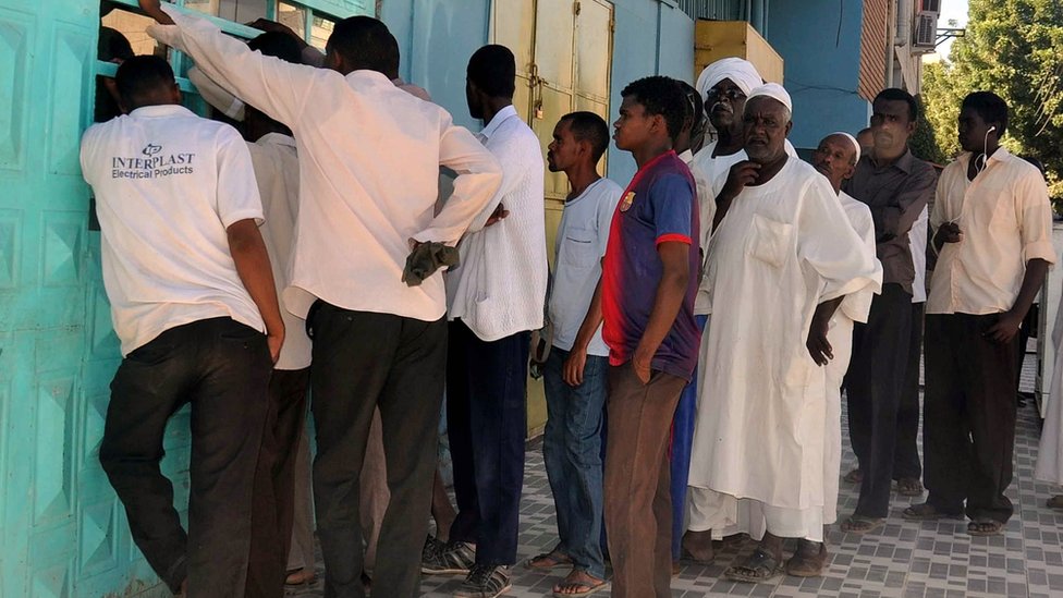 سودانيون ينتظرون شراء أرغفة الخبز