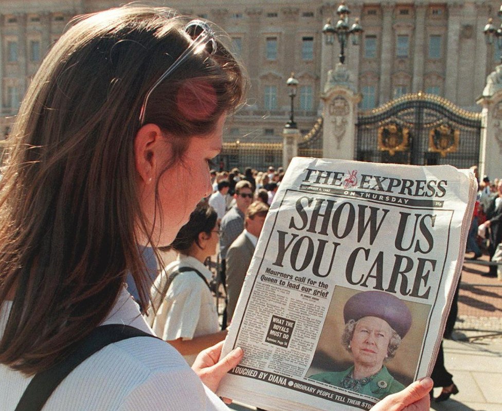 Una mujer lee un periódico con el titular 