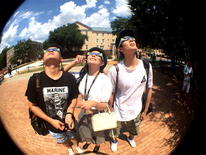 Turistas mirando el cielo con lentes.