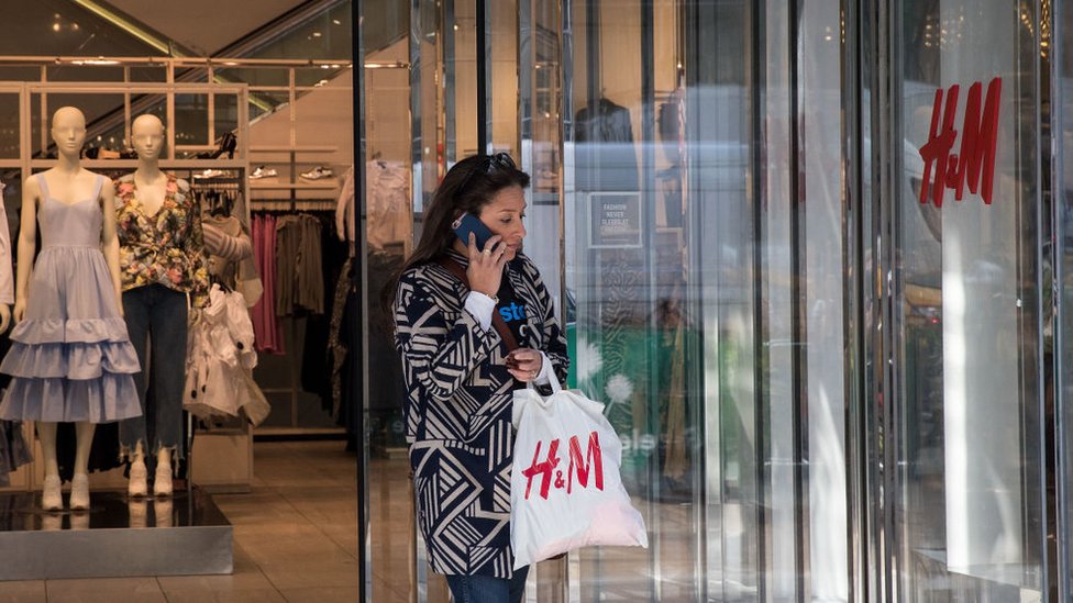 Una mujer sale de una tienda de H&M.