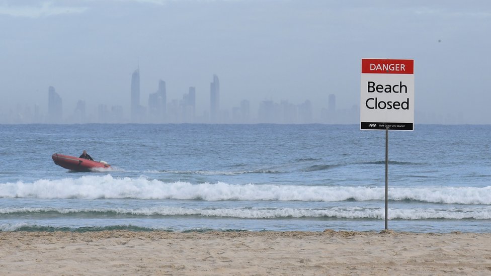 Lifeguards patrol waters off a closed Gold Coast beach after a fatal shark attack