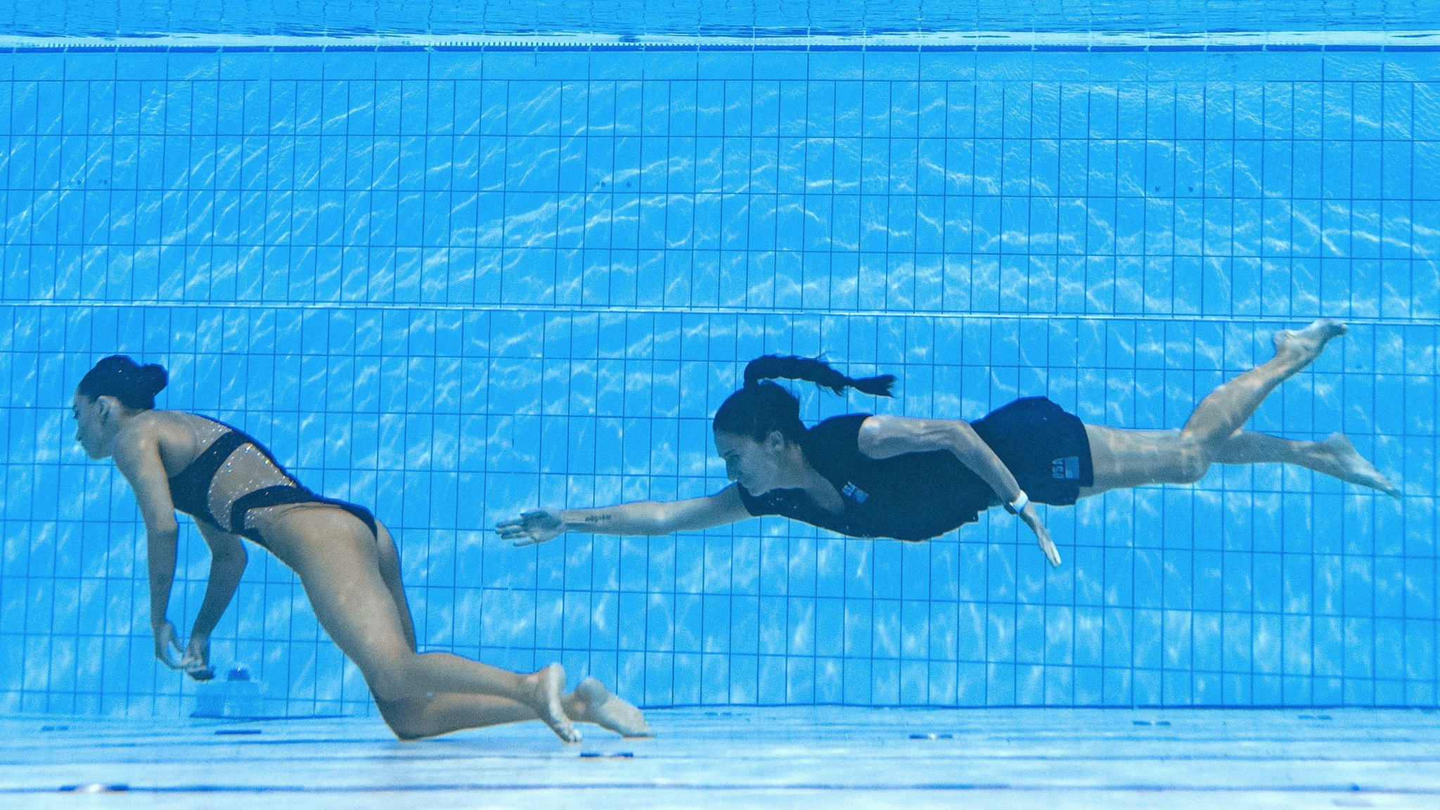 Una mujer joven está haciendo fitness en la piscina. nadar en la
