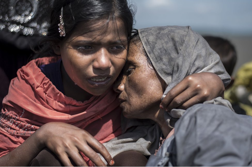 Una niña consuela a su madre en la orilla del río Naf. Han llegado a Bangladesh escapando del ejército de Myanmar.