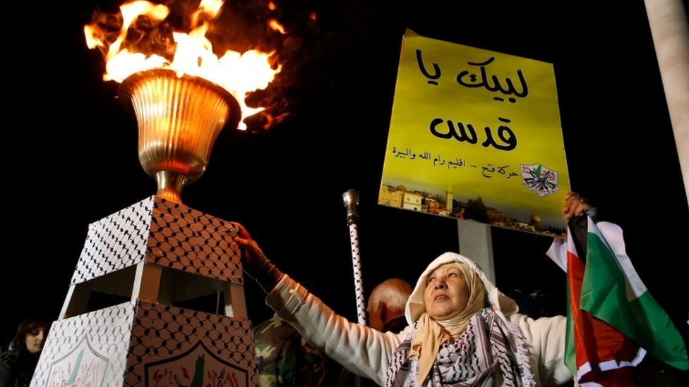 فلسطينية ترفع علن فلسطين ويافطة دفاع عن القدس