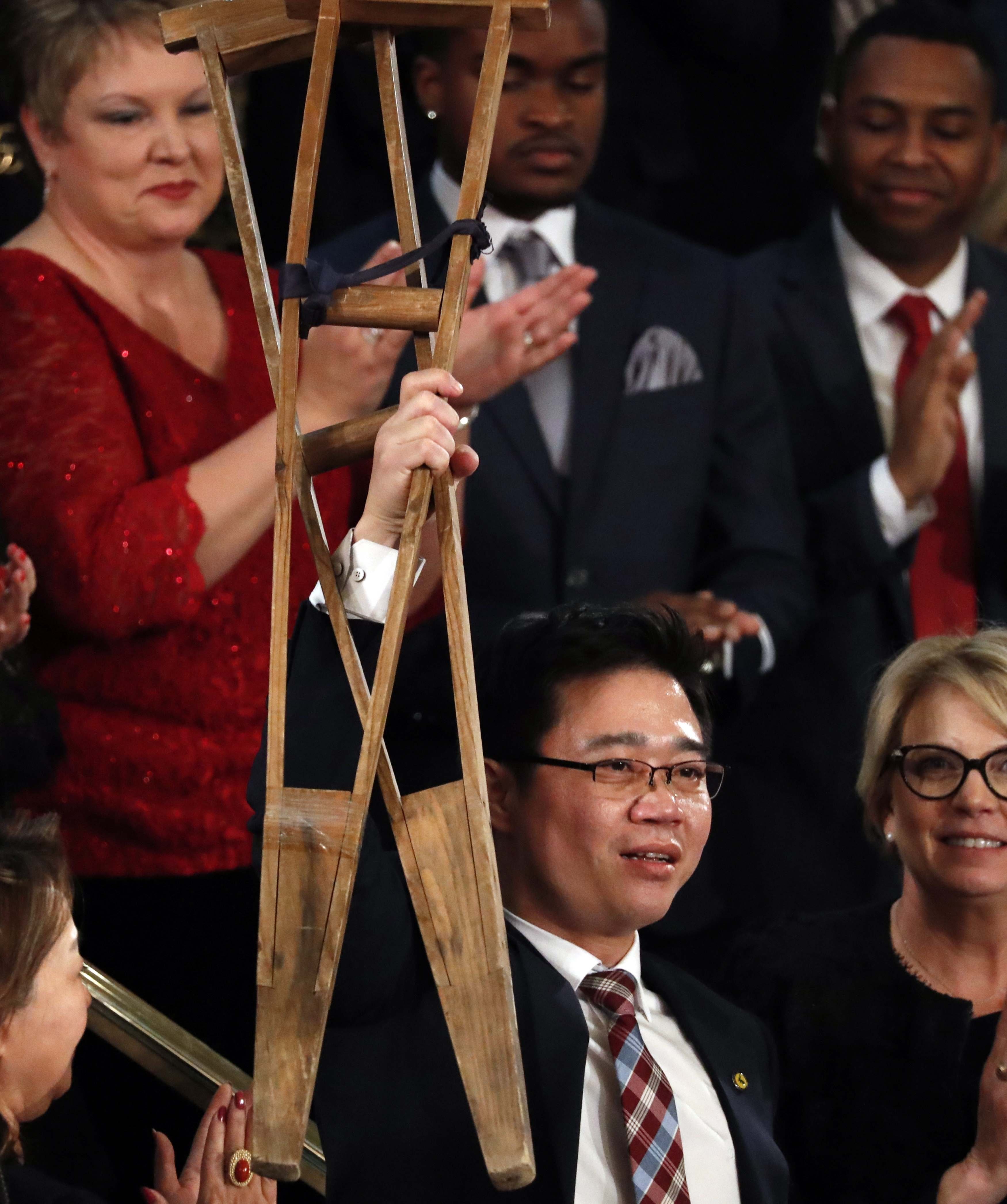 Ji Seong-ho enarbola sus muletas al ser reconocido en el discurso del Estado de la Unión.