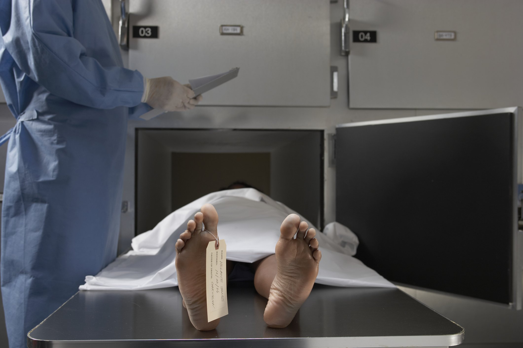 El forense toma notas frente al cadáver en la morgue