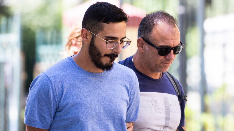 Shymon Hayut es llevado esposado por un policía a un tribunal en Israel