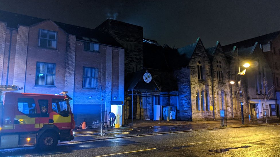 Ein Feuerwehrauto vor dem Gebäude der Belfast Multi-Cultural Association, dem Ort des Feuers