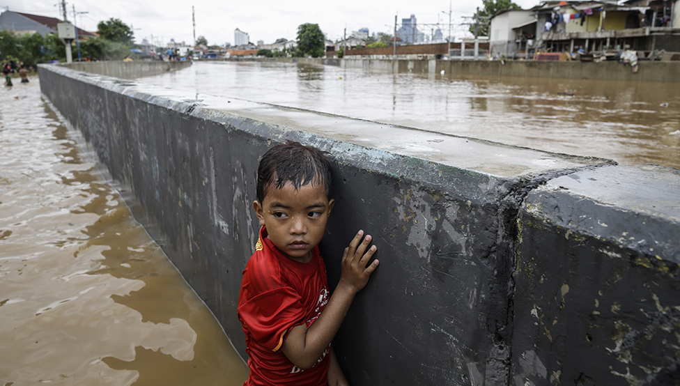 Un niño se aferra a una pared durante una inundación, en Yakarta, Indonesia, en enero de 2020