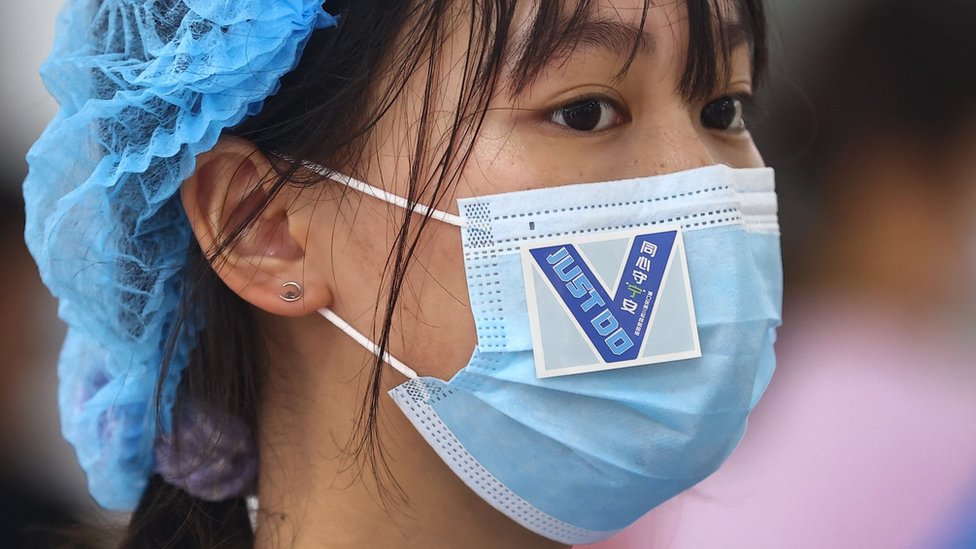 江蘇省南京市浦口區一處核酸檢測點內志願者口罩上貼著鼓勁用的貼紙(中新社圖片29/7/2021)