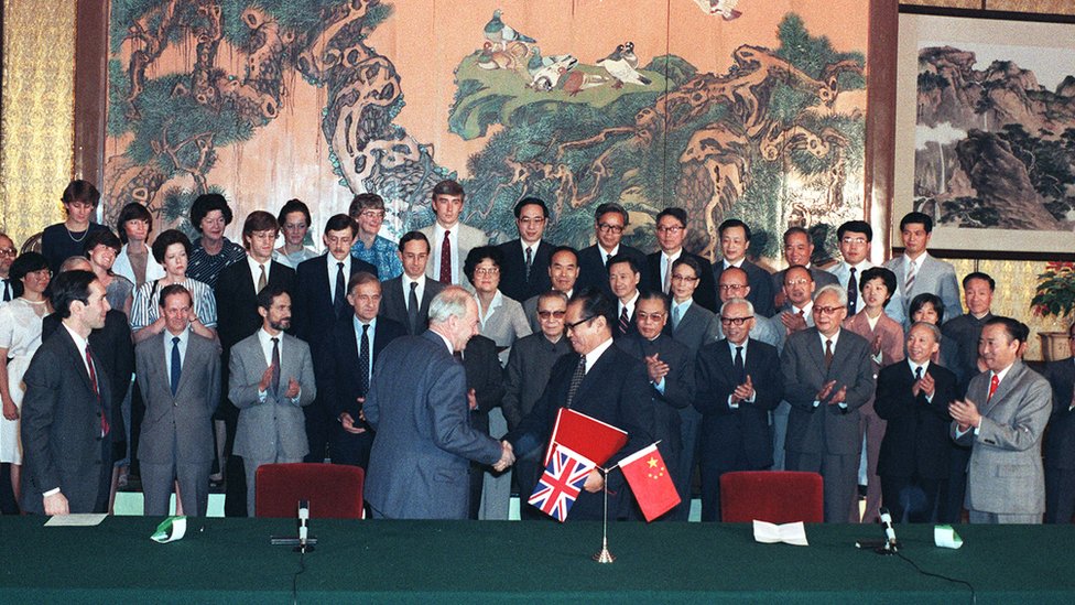 In Beijing, the chairman of the Chinese negotiating team Zhou Nan andthe leader of the British Sir Richard Evans shake hands after signing the draft agreement of the Sino-British Joint Declaration on the Question of Hong Kong. The Joint Declaration states that the United Kingdom will restore the sovereignty of Hong Kong to China on June 30, 1997. (Photo by P Y TANG/South China Morning Post via Getty Images)
