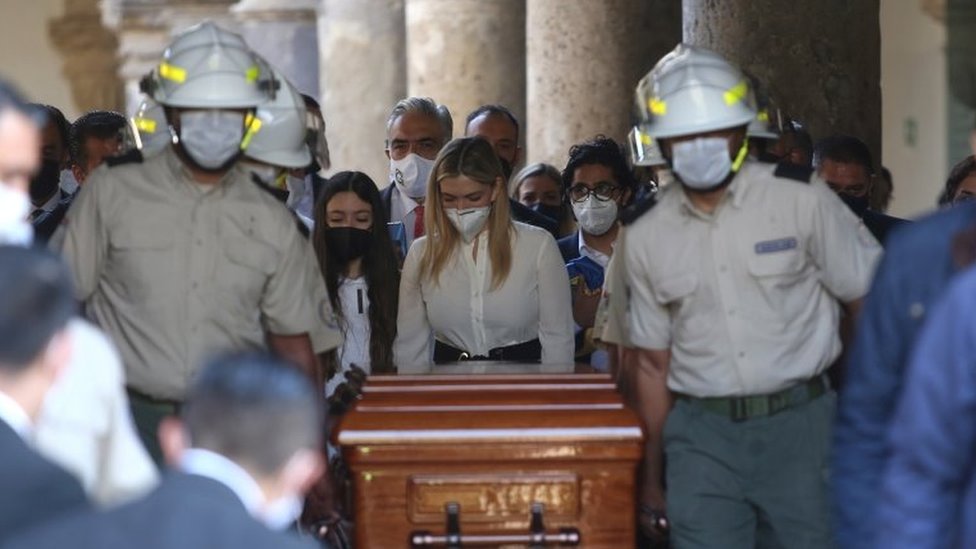 Лорена Хассибе Арриага (C) сопровождает гроб своего мужа, бывшего губернатора Халиско Аристотелеса Сандоваля, во время его прибытия на Конгресс указанного штата для посмертной дани в Гвадалахаре, Мексика, 19 декабря 2020 года.