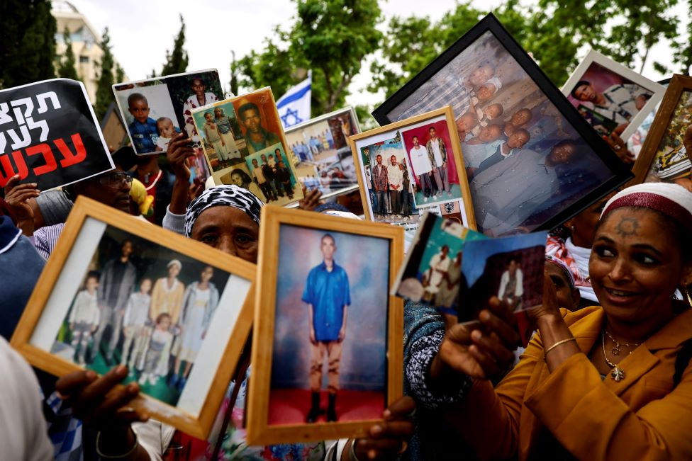 إسرائيليون من أصل إثيوبي يحملون صور أقاربهم خلال مظاهرة تدعو الحكومة الإسرائيلية إلى وقف تجميد الهجرة اليهودية الإثيوبية إلى إسرائيل، خارج الاجتماع الأسبوعي لمجلس الوزراء في القدس، الأحد 28 مايو/ أيار 2023