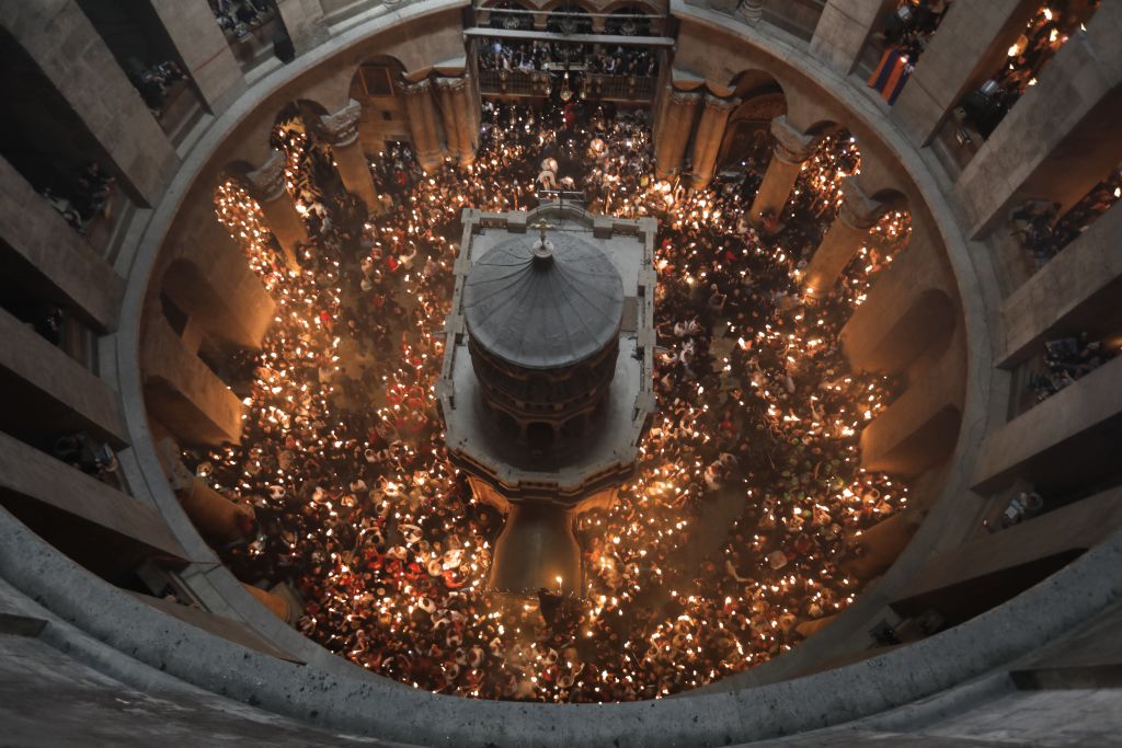 La tumba de Cristo desde los alto y los fieles con velas alrededor durante la Pascua.
