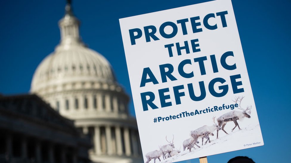 A demonstrator holds a sign against drilling in the Arctic Refuge on the during a press conference outside the US Capitol