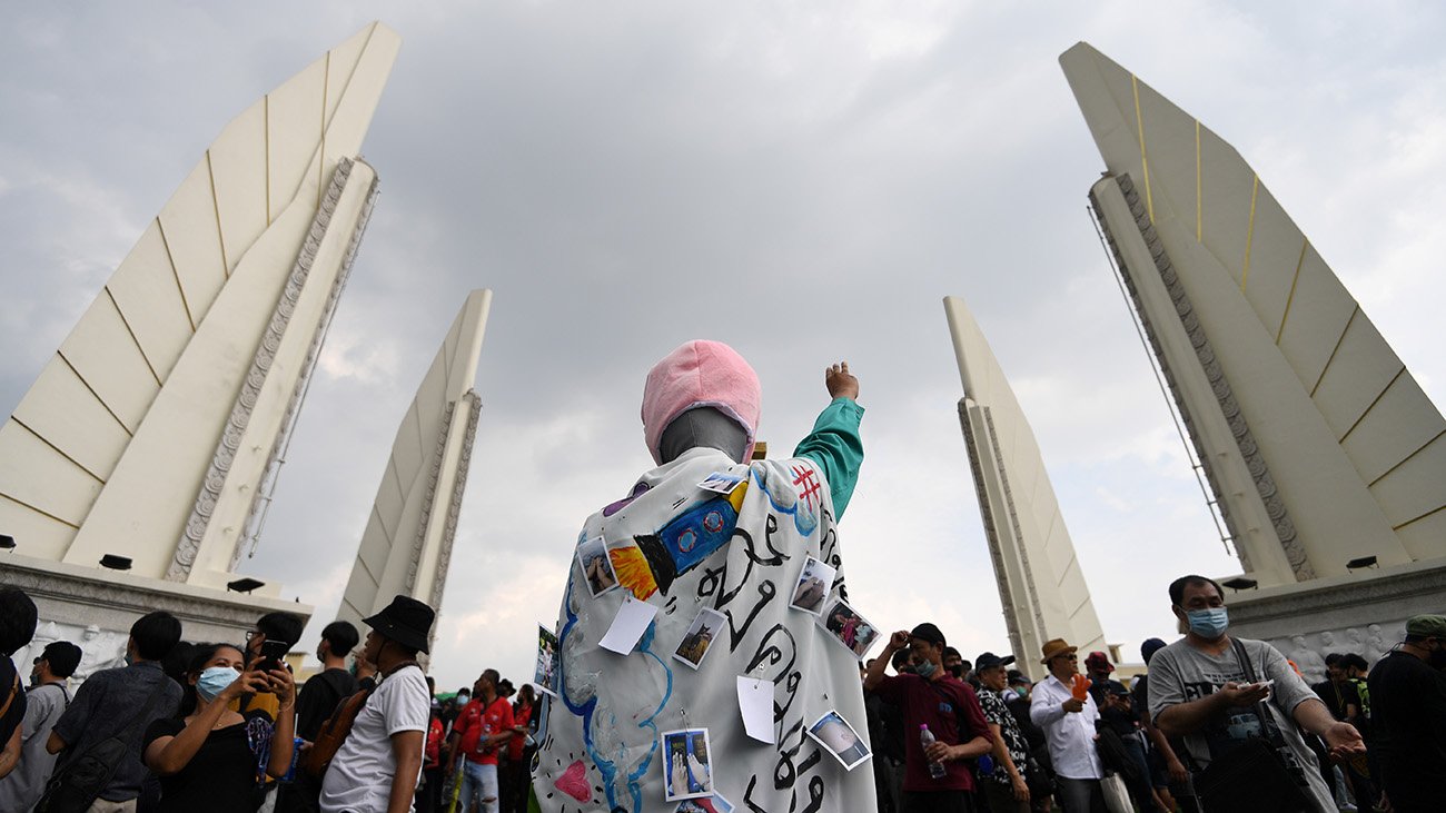 一名示威者在民主紀念碑，舉起三指表示對當局的反抗。