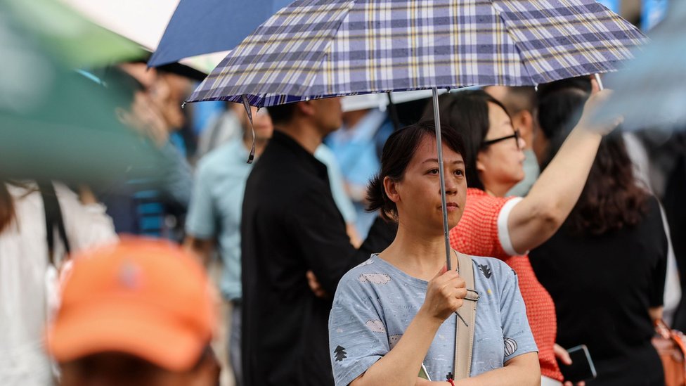 Relatives wait for students outside a school on the first day of China's annual National College Entrance Examination in Beijing, China, 07 June 2024.