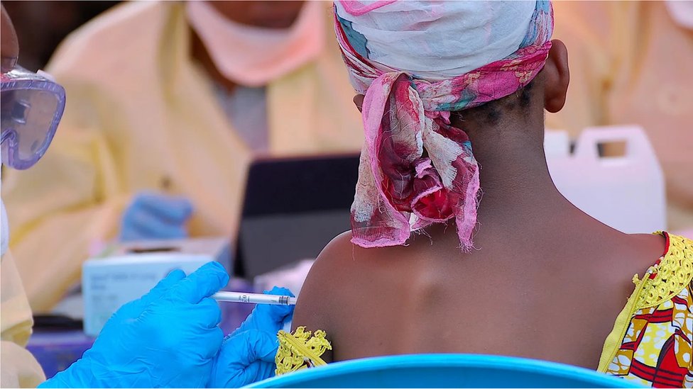 A woman receives a vaccine dose