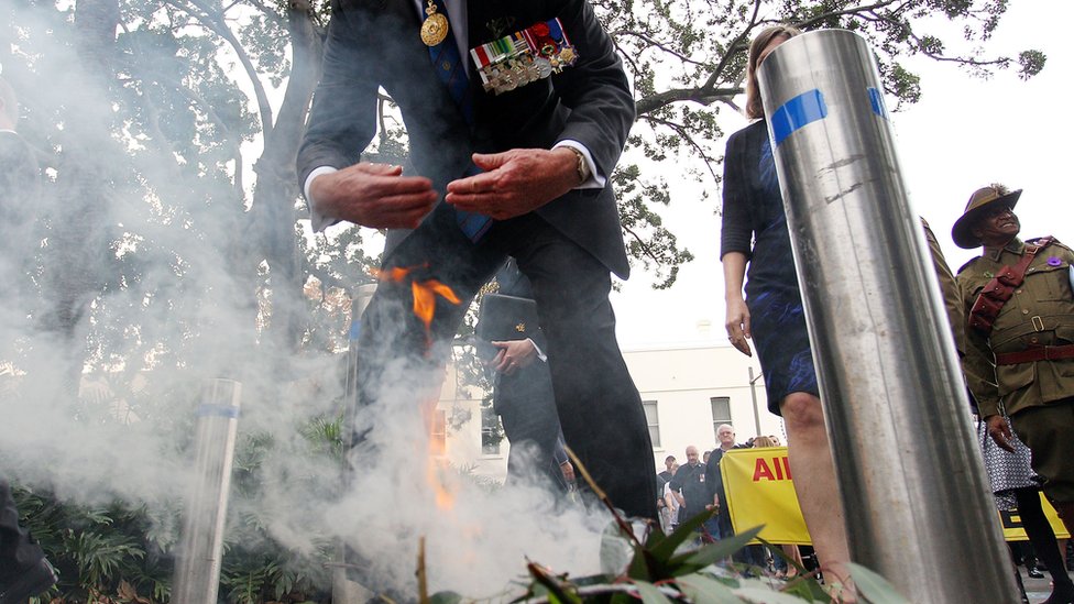 Мужчина принимает участие в традиционной церемонии дыма на службе в День Анзака в Сиднее в 2017 году