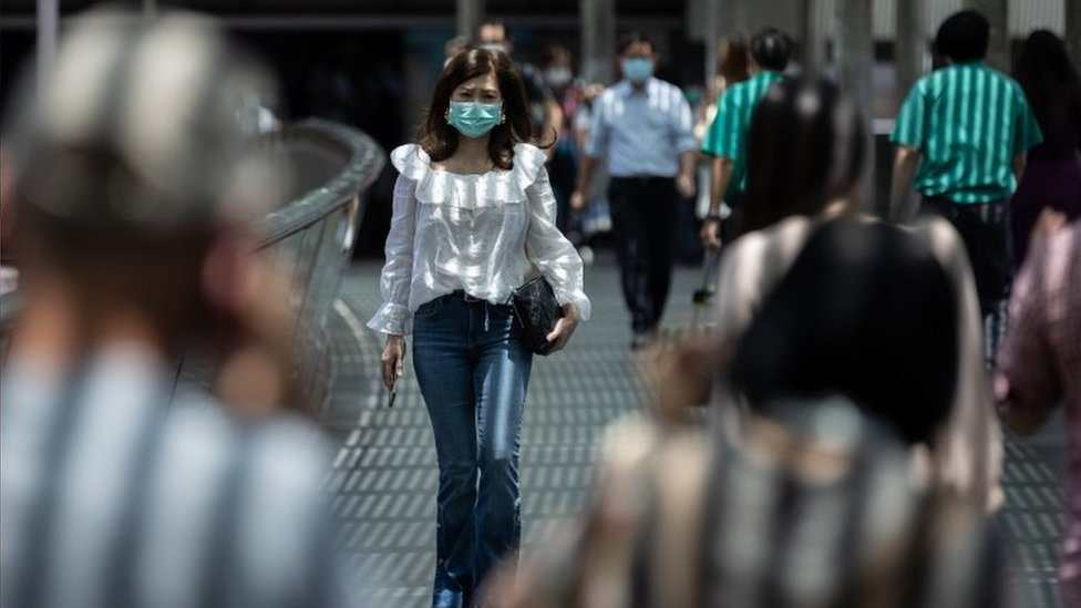 Mulher anda na rua em Hong Kong