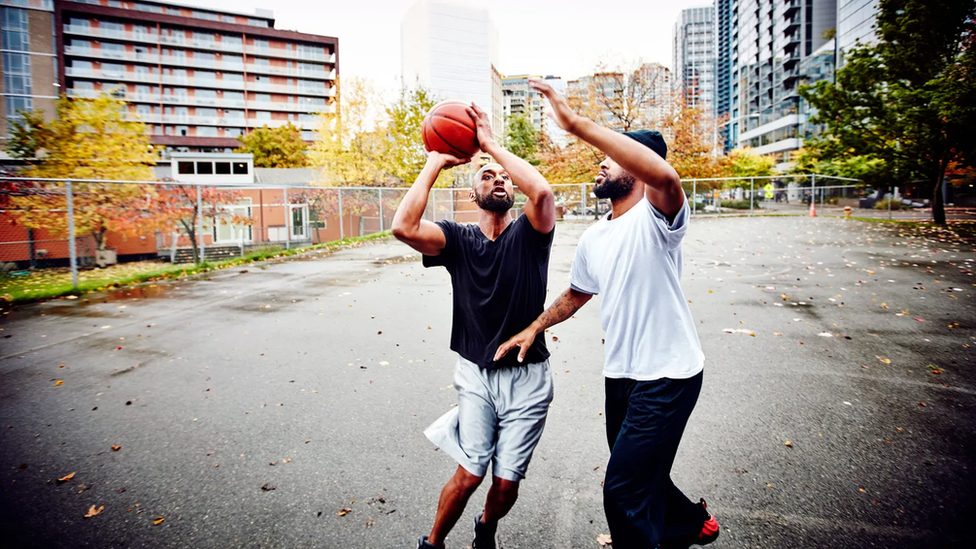 Hermanos jugando al basquet.