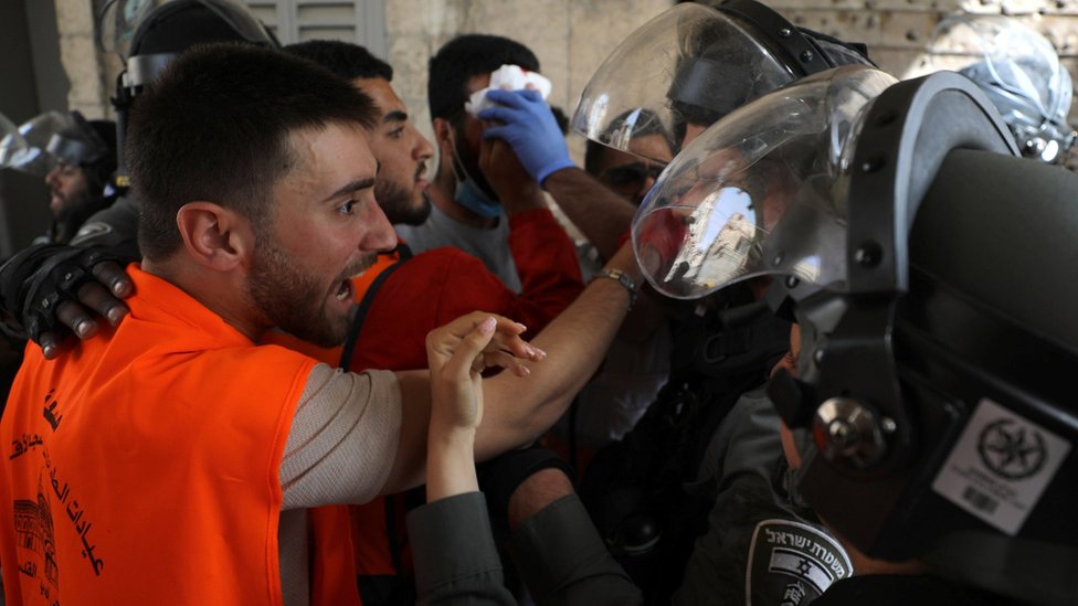 Seorang petugas medis Palestina berdebat dengan polisi Israel dalam bentrokan di luar Masjid Al-Aqsa