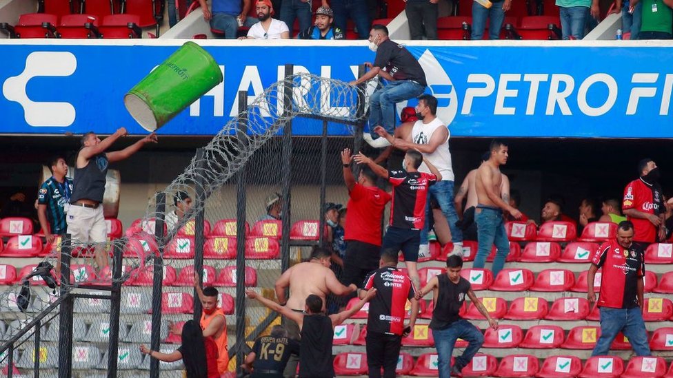 Aficionados intentan saltar una valla en el encuentro entre el Querétaro y el Atlas en México el 5 de marzo