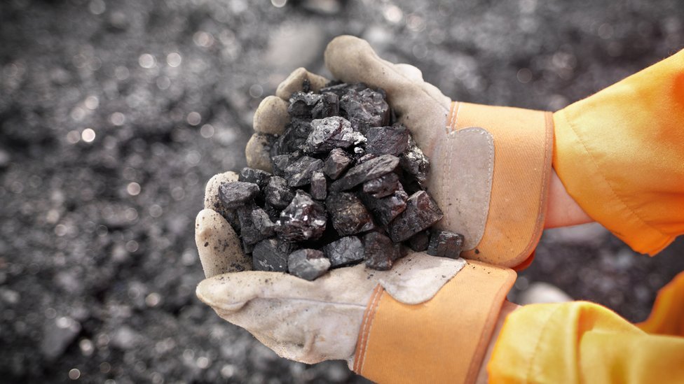 Coal worker with handful Of coal - stock photo