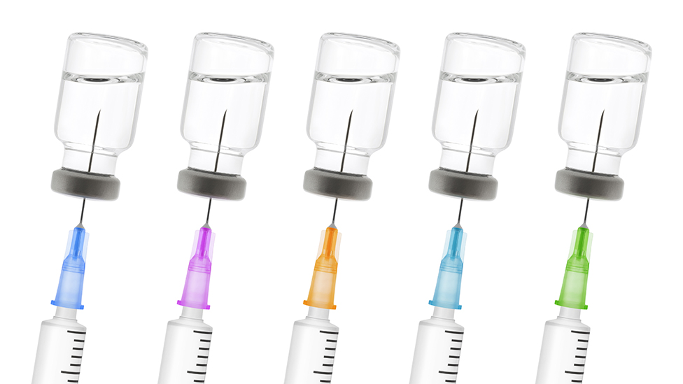 Viales de vacunas y jeringas de colores