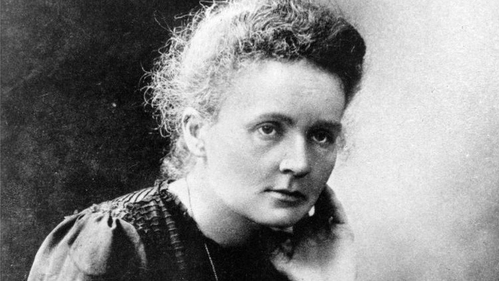 Foto em preto e branco de Marie Curie, que mostra feição séria e olha para a diagonal