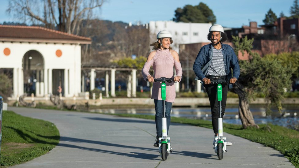Два человека на скутерах Lime Scooters