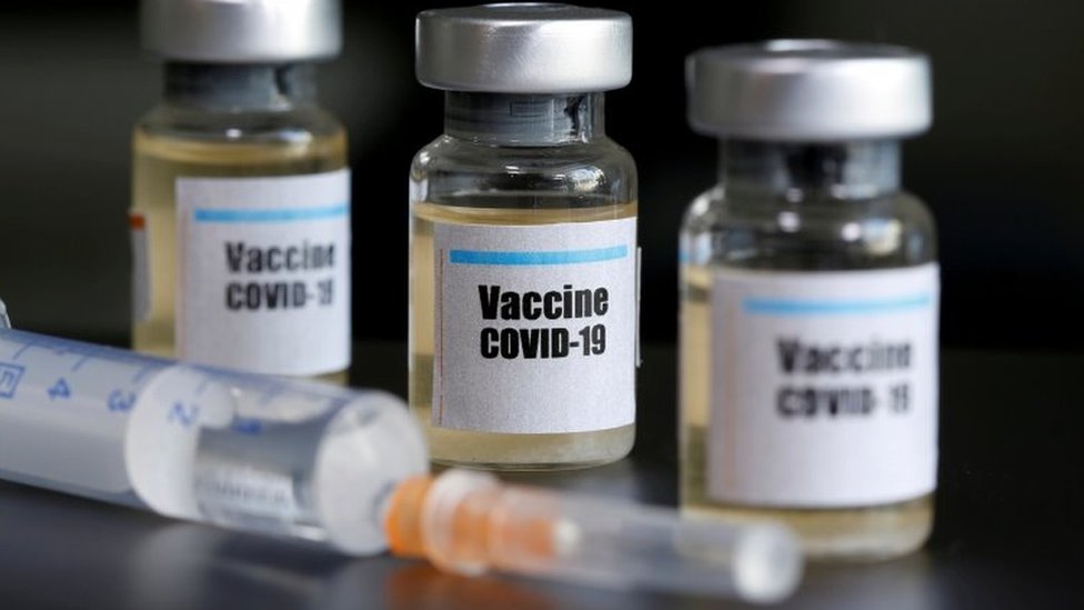Frascos de vacina contra covid-19 ao lado de seringa