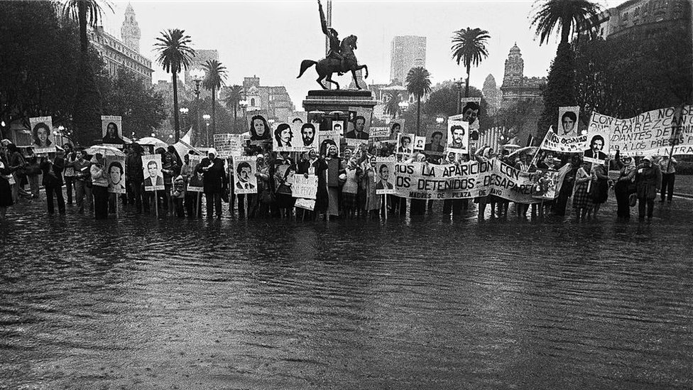 Protesta con fotos de desaparecidos en una plaza inundada
