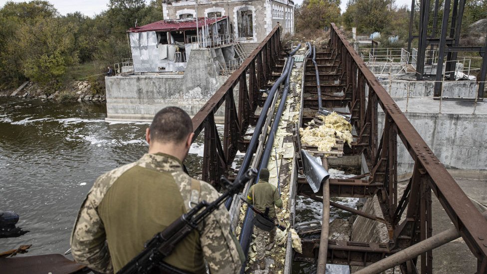 Un soldado intenta atravesar un puente destruido en el río Dnipro.