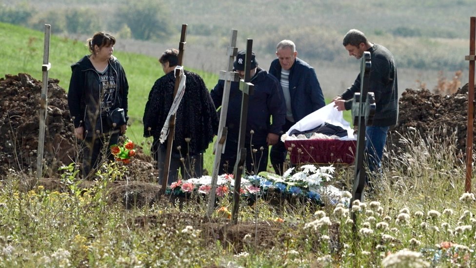A burial takes place at a cemetery